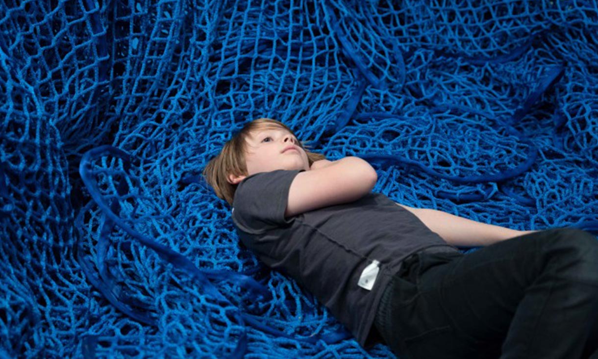 sensorium participant resting on blue netting