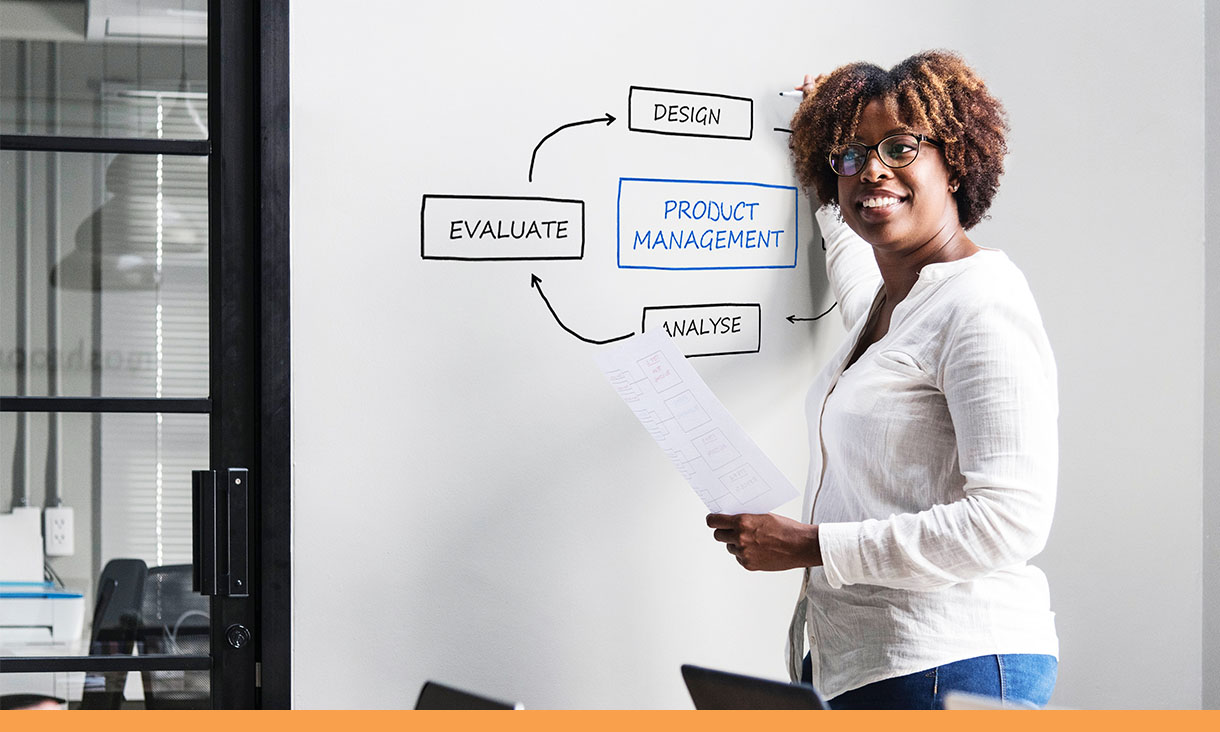 A woman draws a diagram on a whiteboard.
