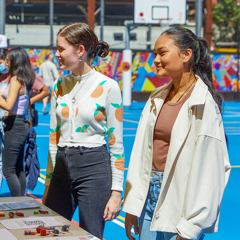 Two students outdoors at a stall