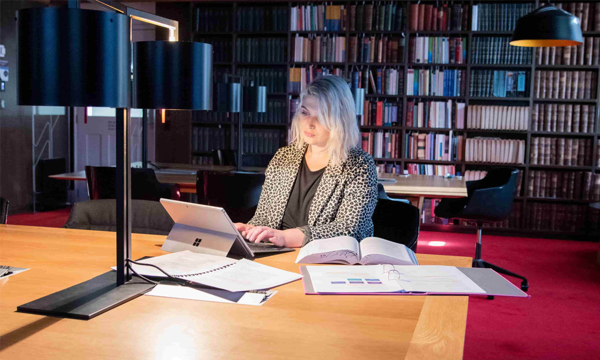 Martha, an RMIT Law student sitting at a desk with a laptop and open books